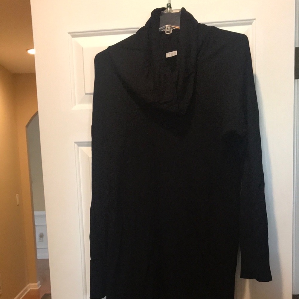 Short black dress with turtle neck collar.